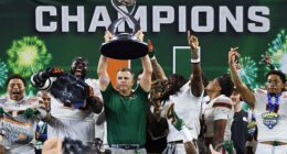 Miami head coach Mario Cristobal holds the Field Scovell Trophy following the Cotton Bowl