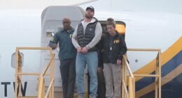 Pictured: Ryan Wedding in handcuffs after landing in the US following his arrest in Mexico City
