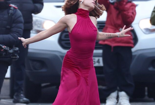 Raye, 28, twirled vigorously in a hot pink dress as she shut down east London to film an exciting new music video on Tuesday