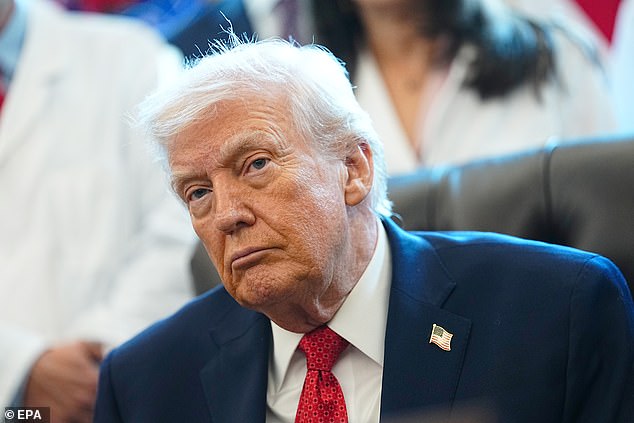 Trump signs an executive order in the Oval Office in the White House on December 18