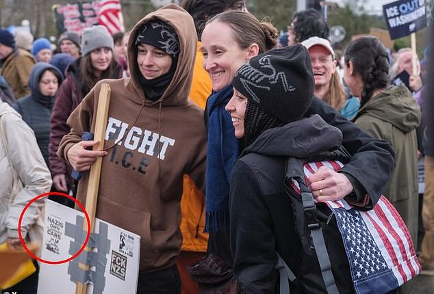 Seattle's liberal new mayor has been caught posing for a photograph with a far-left activist holding a placard calling for arson attacks against their political enemies, as shown above