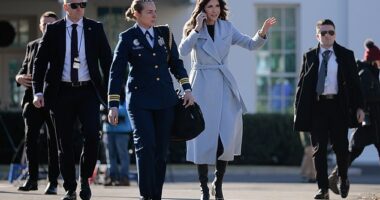 U.S. Secretary of Homeland Security Kristi Noem is accompanied by security agents as she walks out of the White House on January 15, 2026