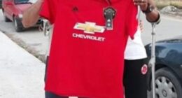 A man managed to dupe an entire Greek island that he was the legendary Manchester United player Remi Moses. Here he is pictured with a fan holding a United shirt in Zakynthos