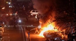 Iranian demonstrators gather in a street during a protest over the collapse of the currency's value, in Tehran, Iran