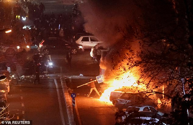 Iranian demonstrators gather in a street during a protest over the collapse of the currency's value, in Tehran, Iran