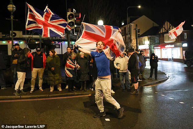 Photos show protesters gathered on Crowborough's High Street last night, holding England and Union Jack flags