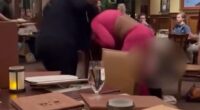 Video from the Cork & Bull Chophouse in Chesapeake shows a women in a black ensemble grabbing a woman wearing hot pink by her hair and punching her repeatedly on November 6