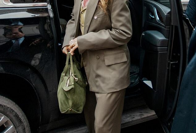 Lively wore an olive-hued oversized suit paired with a green cardigan and striped, pink collared shirt beneath. She also toted a green suede bag and wore matching green shoes