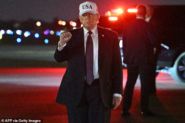 US President Donald Trump makes a fist after he steps off Air Force One upon arrival at Palm Beach