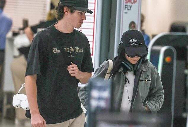 A famously reclusive singer was spotted at Sydney Airport on Friday, cutting a low-key figure as she strolled through the terminal with her lookalike brother... so can you guess who she is?