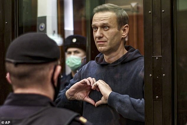 Russian opposition leader Alexei Navalny makes a heart with his hands as he appears in court in Moscow on February 2, 2021