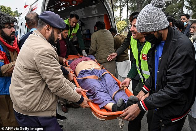 People shift an injured man to a hospital following an explosion at a mosque in Islamabad on February 6, 2026
