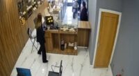 Further footage from inside the shop shows the moped driver ram the bike straight through the front door as a customer spoke to the shop attendant