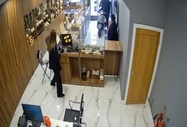 Further footage from inside the shop shows the moped driver ram the bike straight through the front door as a customer spoke to the shop attendant