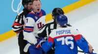 Officials separate United States' Brady Tkachuk (7) and Slovakia's Martin Pospisil (76) during the first period of Team USA's semifinals win on Thursday in Milan, Italy