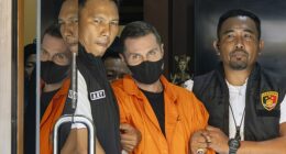 Steven Lyons is escorted by police officers at the Bali Police headquarters in Denpasar, Bali, Indonesia, March 31 2026
