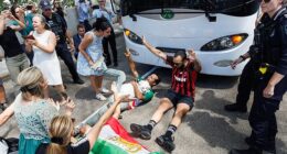 Supporters surrounded the team bus while chanting 'save our girls' in chaotic scenes as the Iranian team's bus tried to leave their Gold Coast hotel on Tuesday afternoon (pictured)