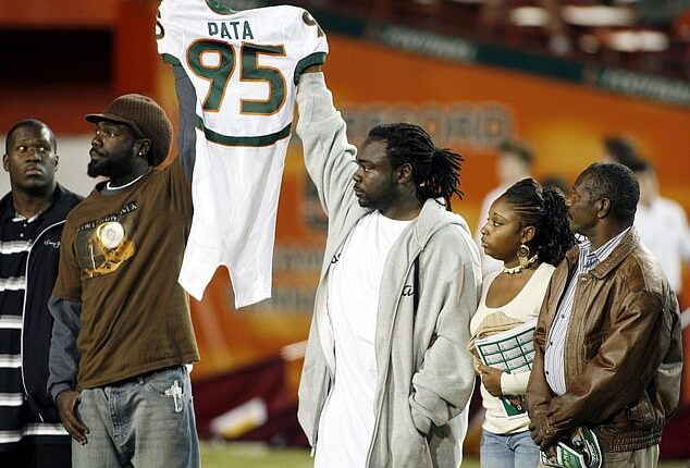 Bryan Pata's family holds up his jersey at the beginning of a college football game back in 2006
