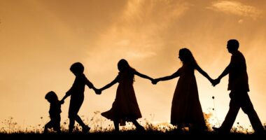 family silhouette against sunset