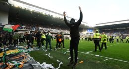 An ultra turns to face the Celtic fans in the Broomloan Stand after making his way on the pitch