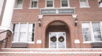 A brick building with a "Lipscomb Academy" sign on it