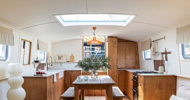 The boat’s main room features an open-plan kitchen and living room with a concealed snug at the other end that Rosanna opens up to enlarge the space. The kitchen is made from stained birch ply with cupboard handles from Etsy.