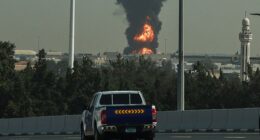 TOPSHOT - A smoke plume rise from an ongoing fire at Dubai International Airport in Dubai on March 16, 2026. Flights were gradually resuming at Dubai airport on March 16, previously the world's busiest for international flights, the airport operator said, after a "drone-related incident" sparked a fuel tank fire nearby, as Iran kept up its Gulf attacks. (Photo by Fadel SENNA / AFP via Getty Images) /