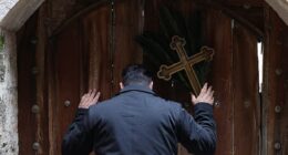 Issa Kassissieh (pictured), a Palestinian Christian who is popular for being the Santa Claus of the city, stands holding a cross and a palm frond at the doors of the Church of the Holy Sepulchre after finding them locked, following the cancellation of the traditional Palm Sunday procession from the Mount of Olives