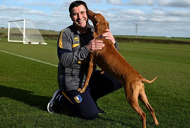 Nigel Clough at Mansfield's training ground with his dog Bobbie. Clough's team take on Premier League leaders Arsenal in the FA Cup on Saturday