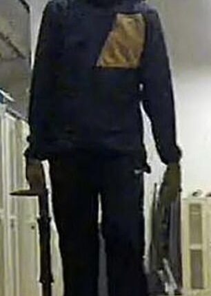 A man with a hat and face mask appears to be carrying objects out of the building on base