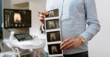 woman holding ultrasound photos