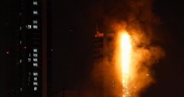 As the conflict in Iran spreads throughout the Middle East, fears are growing that the world may soon spiral into a WWIII. Pictured: smoke rises from a burning building hit by an Iranian drone strike in Bahrain on February 28