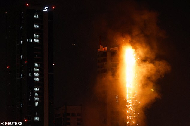 As the conflict in Iran spreads throughout the Middle East, fears are growing that the world may soon spiral into a WWIII. Pictured: smoke rises from a burning building hit by an Iranian drone strike in Bahrain on February 28