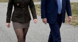 Foster posed on the tarmac with President Trump, sporting high heels and a slicked-back hairstyle. (This photo of Foster and Trump is AI-generated)