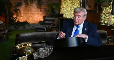 President Donald Trump signs a replica of a guitar Elvis Presley used in 1973