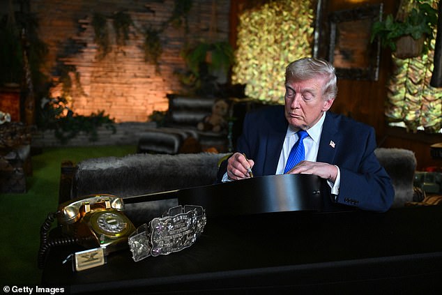 President Donald Trump signs a replica of a guitar Elvis Presley used in 1973