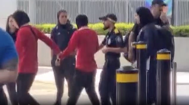 Afsaneh Chatrenoor is pulled towards the waiting bus by one fellow Iranian player, another close behind as the 27-year-old is dragged off to eventually catch a plane out of Australia