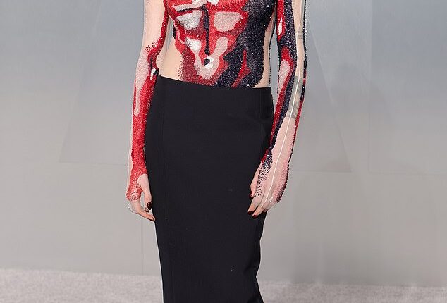 English model Cara Delevingne, 33, arrived in a long-sleeve bodysuit that was adorned with red, black and white sequins to resemble a male torso. She finished the look with a black pencil skirt and wore her hair in a slick updo