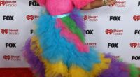 Singer Cheryl Porter, 53, made a very bold entrance in a rainbow-colored gown that boasted bright pink puff-ball shoulders and a tiered tulle skirt that flowed down into a dramatic train