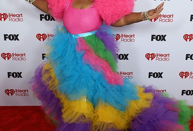 Singer Cheryl Porter, 53, made a very bold entrance in a rainbow-colored gown that boasted bright pink puff-ball shoulders and a tiered tulle skirt that flowed down into a dramatic train