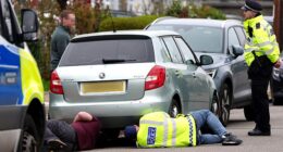 Police check the engine and undercarriage of a silver-coloured Skoda in a road in Finchley last Friday