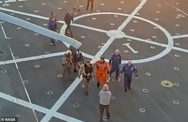 All four members of the Artemis II crew were supported by a person on each side, while a third assistant pushed a wheelchair behind them in case it was needed, after arriving back from their moon mission