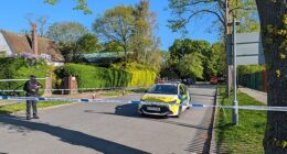 Police officers patrol a cordon set up outside the synagogue in the early hours of Sunday morning