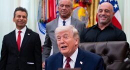 Joe Rogan and US Secretary of Health and Human Services Robert F. Kennedy Jr. look on as President Trump signs the executive order on April 18, 2026