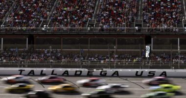 Cars race past the grandstands at Talladega Superspeedway during a NASCAR Cup Series event