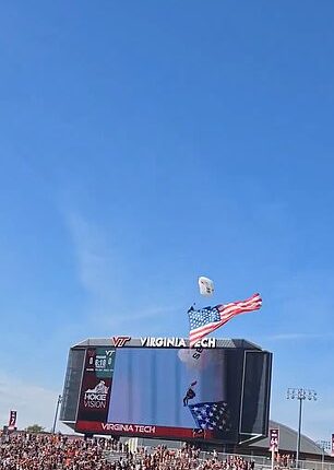 A parachutist was left dangling from the scoreboard after pre-game theatrics went wrong
