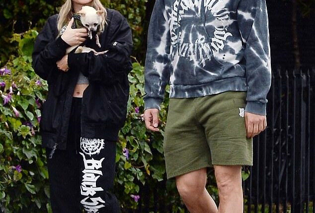 Joe Manganiello and his girlfriend Caitlin O'Connor, 33, bundled up in rain gear to venture out for a walk during the storm that has been flooding Los Angeles