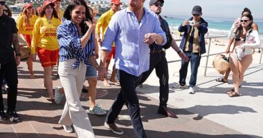 Prince Harry, and Meghan, the Duke and Duchess of Sussex, walk along the boardwalk after meeting volunteer first responders from Bondi Surf Bathers' Life Saving Club, during a visit to Bondi Beach