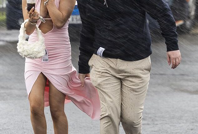 Glamorous racegoers at The Coral Scottish Grand National in Ayrshire, Scotland, were hit with rainy weather
