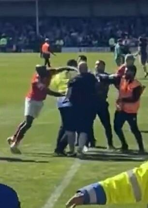York City midfielder Hiram Boateng was seen striking out at a Rochdale fan amid a pitch invasion in an apparent retaliation after being pushed to the ground